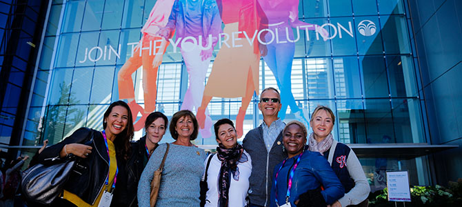 Nu Skin distributors pose for a picture with Nu Skin executive (put name of person if you can confirm who that is) in front of the Nu Skin corporate office in Provo, Utah.